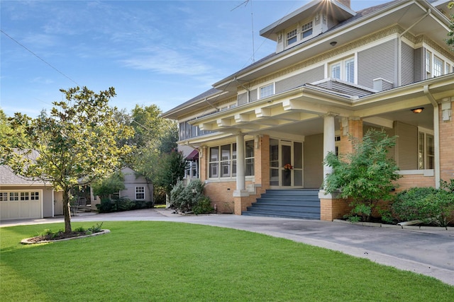 traditional style home featuring entry steps, brick siding, and a front yard