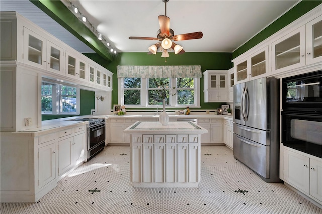 kitchen featuring black appliances, ceiling fan, a kitchen island, and white cabinetry