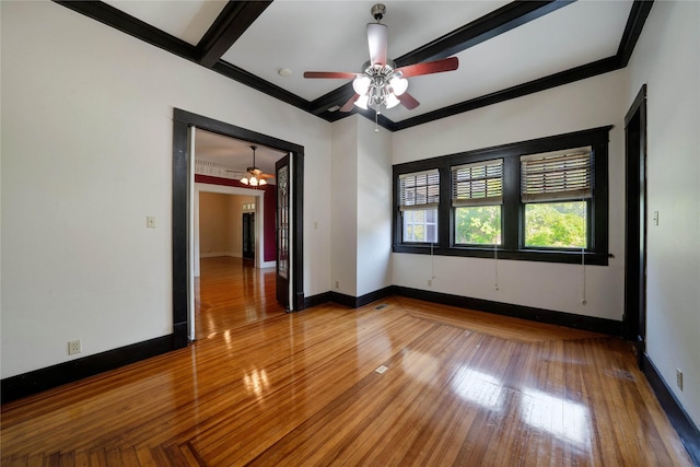 unfurnished room with crown molding, baseboards, and wood finished floors