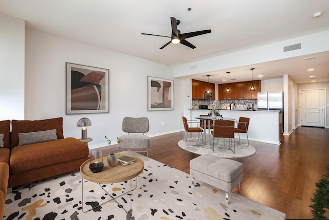 living room with ceiling fan and dark wood-type flooring