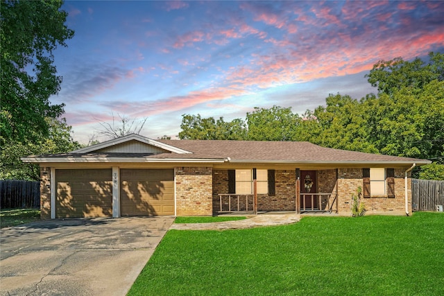 ranch-style house featuring a garage and a lawn