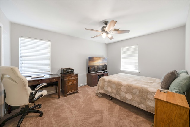 bedroom featuring ceiling fan, light carpet, and multiple windows