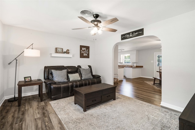 living room with ceiling fan and dark hardwood / wood-style flooring