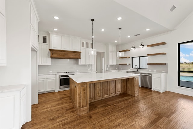 kitchen with light stone countertops, appliances with stainless steel finishes, dark hardwood / wood-style flooring, a center island, and white cabinets