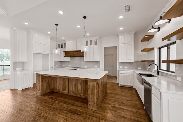 kitchen featuring a large island, light stone counters, dark hardwood / wood-style flooring, white cabinetry, and sink