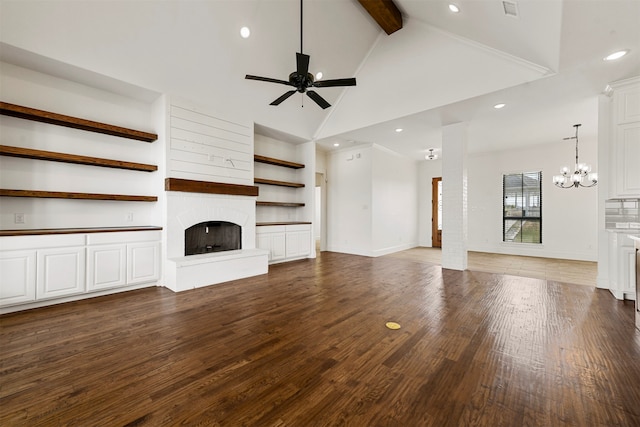 unfurnished living room with beam ceiling, dark hardwood / wood-style flooring, high vaulted ceiling, ceiling fan with notable chandelier, and a fireplace