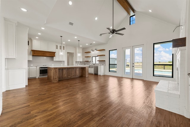 unfurnished living room featuring dark hardwood / wood-style floors, beam ceiling, high vaulted ceiling, and ceiling fan