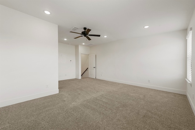 empty room featuring ceiling fan and light colored carpet