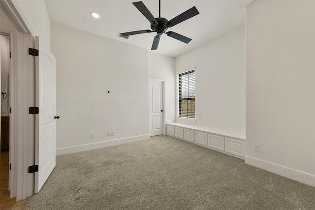 carpeted spare room featuring ceiling fan