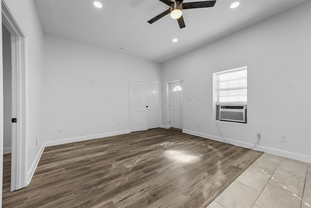 unfurnished room with cooling unit, wood-type flooring, and ceiling fan