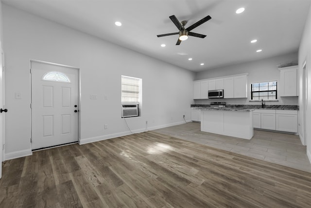 kitchen featuring white cabinetry, a center island, light wood-type flooring, and ceiling fan