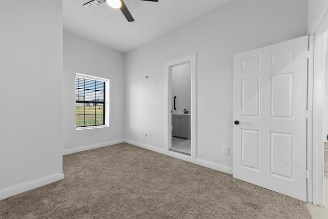 unfurnished bedroom featuring connected bathroom, light colored carpet, and ceiling fan