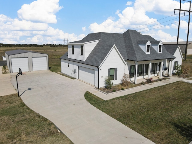 view of front of property featuring a front yard, an outdoor structure, and a garage