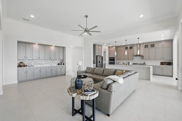 living area with visible vents, crown molding, a ceiling fan, and recessed lighting