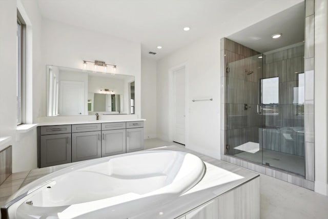 bathroom featuring recessed lighting, a shower stall, a garden tub, and vanity