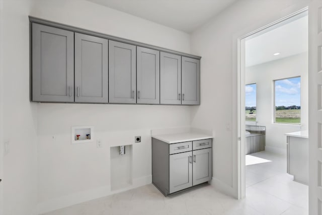 laundry area with electric dryer hookup, washer hookup, and cabinets