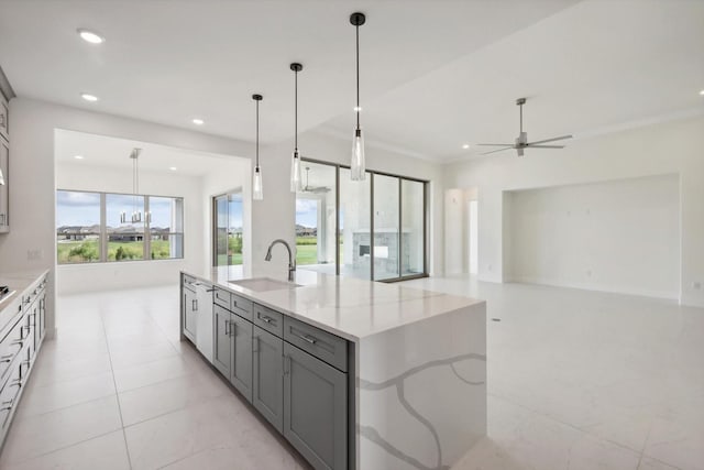 kitchen with a sink, open floor plan, a kitchen island with sink, a ceiling fan, and gray cabinets