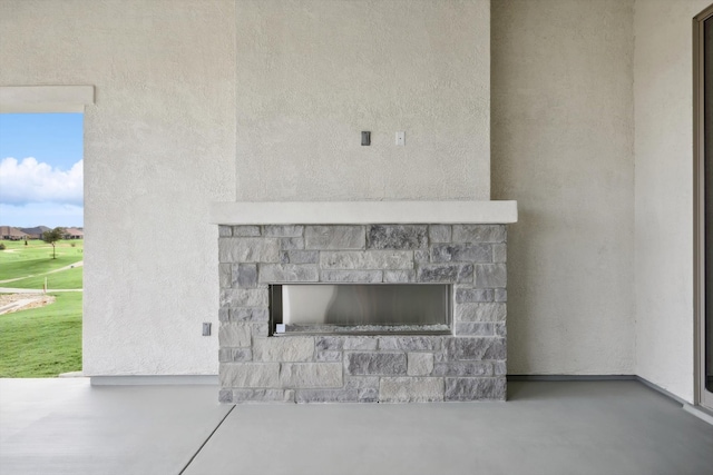 room details with a stone fireplace and concrete flooring