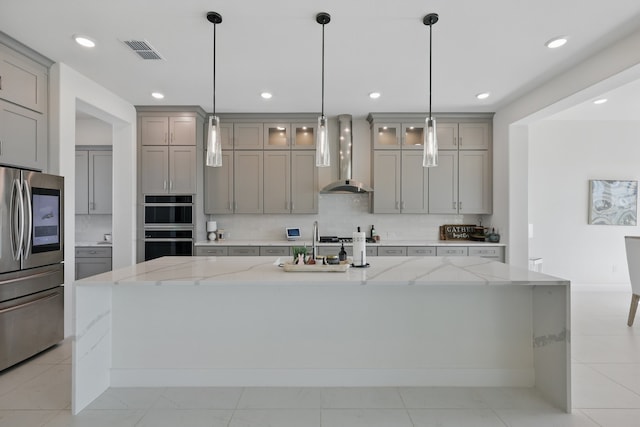 kitchen with smart refrigerator, backsplash, gray cabinetry, visible vents, and wall chimney exhaust hood