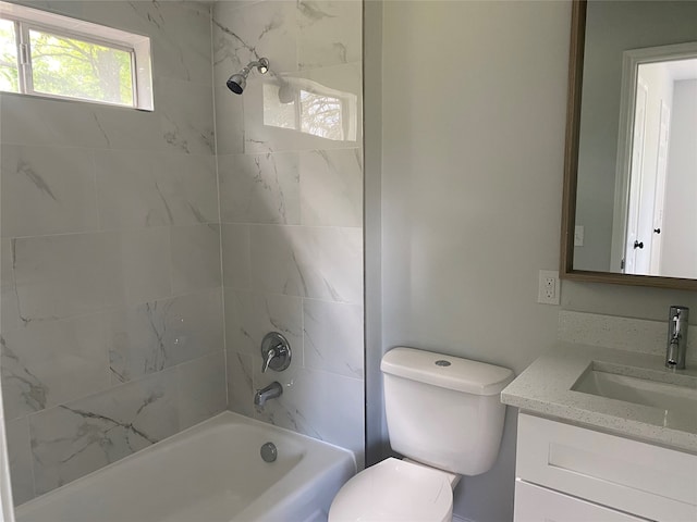 full bathroom with tiled shower / bath, vanity, and toilet