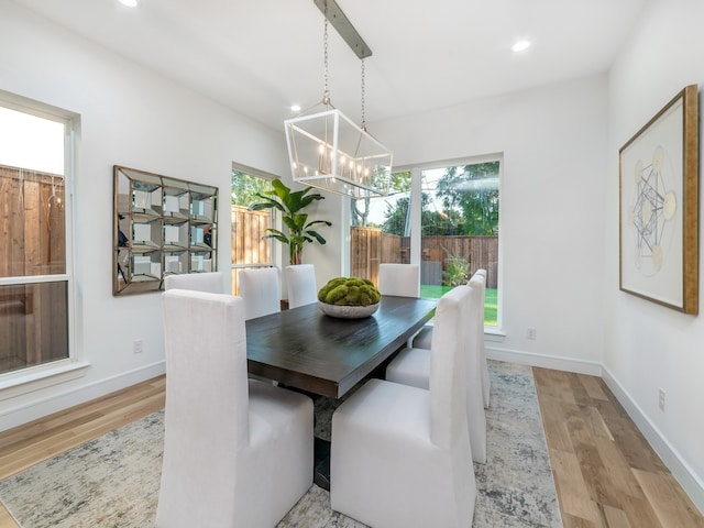 dining area with light hardwood / wood-style floors and a notable chandelier