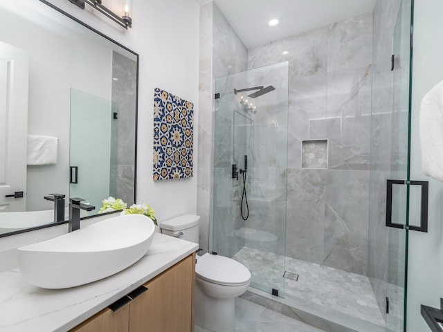 bathroom featuring vanity, toilet, and an enclosed shower