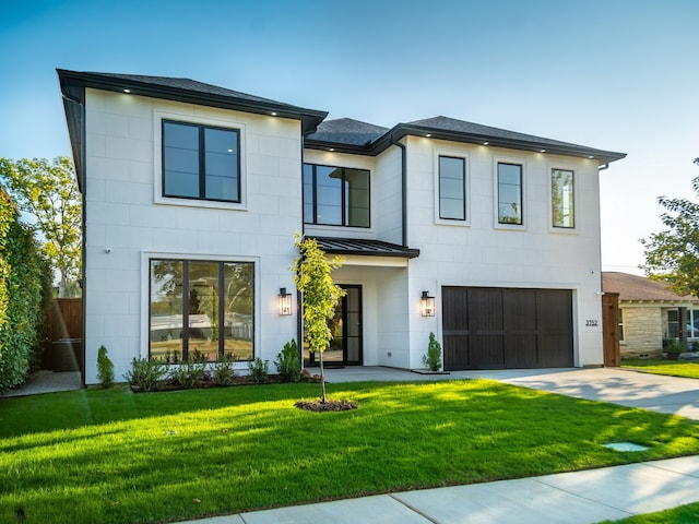 view of front of home with a garage and a front lawn