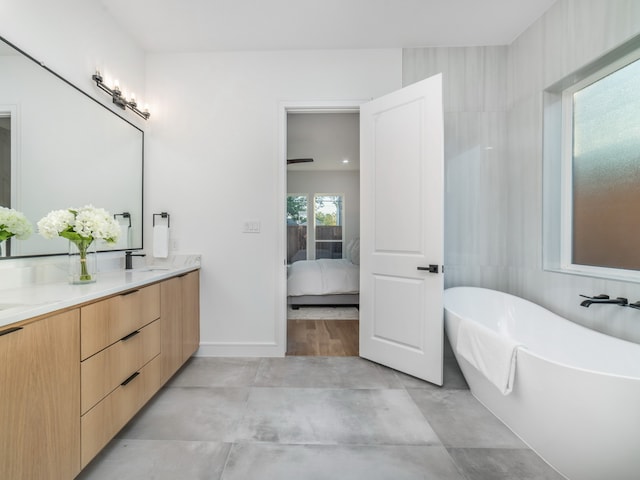 bathroom with a washtub, concrete flooring, and vanity