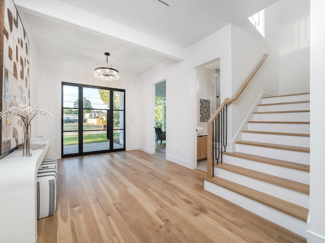 foyer featuring light wood-type flooring and an inviting chandelier