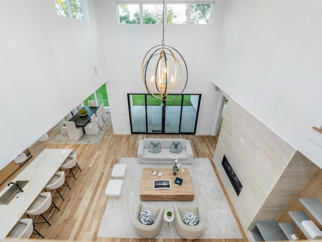 living room with a healthy amount of sunlight, an inviting chandelier, and light hardwood / wood-style flooring