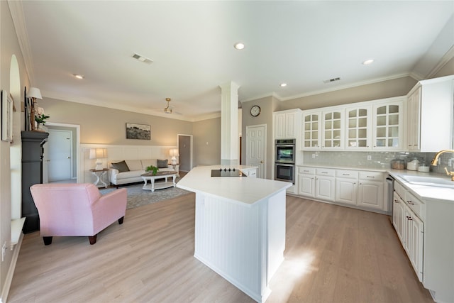 kitchen featuring appliances with stainless steel finishes, light countertops, a sink, visible vents, and open floor plan