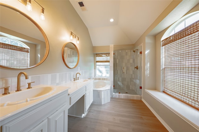 bathroom featuring lofted ceiling, plus walk in shower, vanity, and a healthy amount of sunlight