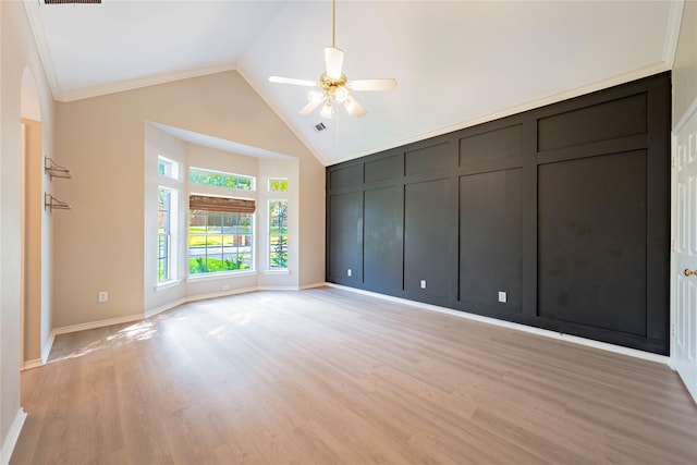 spare room featuring light wood finished floors, baseboards, visible vents, a ceiling fan, and high vaulted ceiling