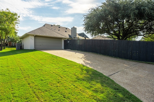 view of side of home featuring a garage and a yard