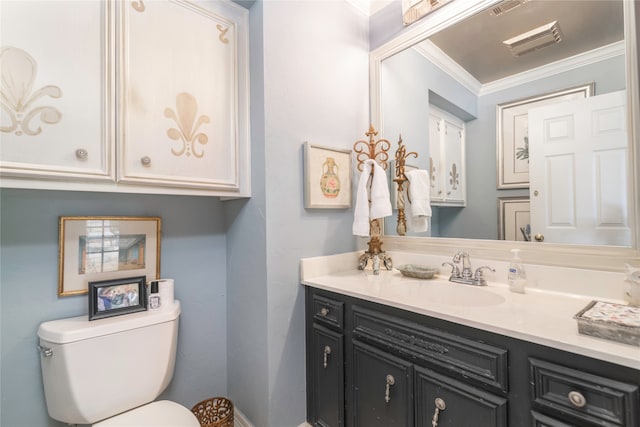 bathroom with ornamental molding, vanity, and toilet