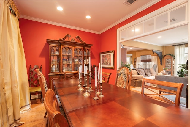 dining room featuring ornamental molding and light hardwood / wood-style floors