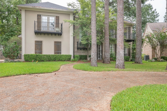 view of front of house featuring a front yard and a balcony