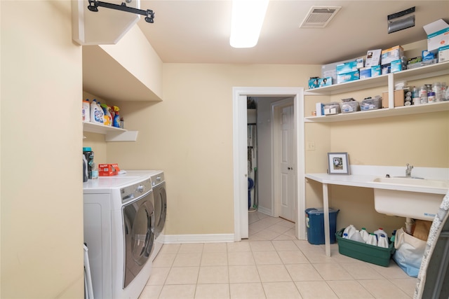 clothes washing area featuring washer and dryer and light tile patterned floors