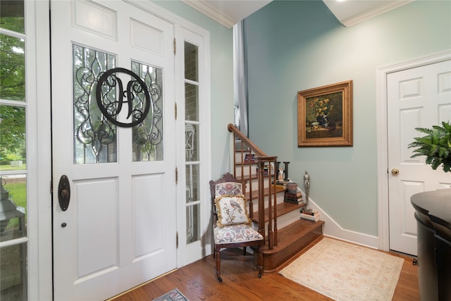 entrance foyer featuring hardwood / wood-style flooring, crown molding, and a healthy amount of sunlight