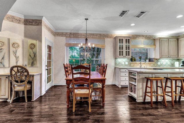 dining space with a chandelier, dark hardwood / wood-style flooring, crown molding, and sink