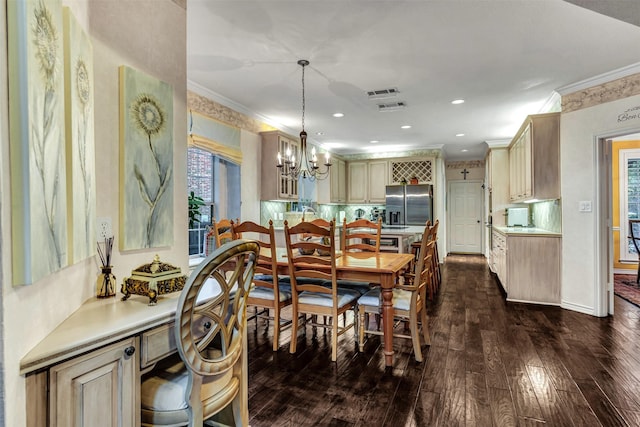 dining room with crown molding, dark hardwood / wood-style flooring, and a chandelier