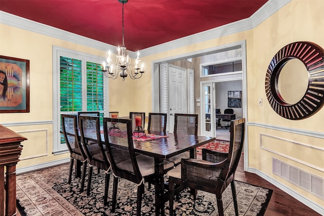 dining area with wood-type flooring, crown molding, and a notable chandelier