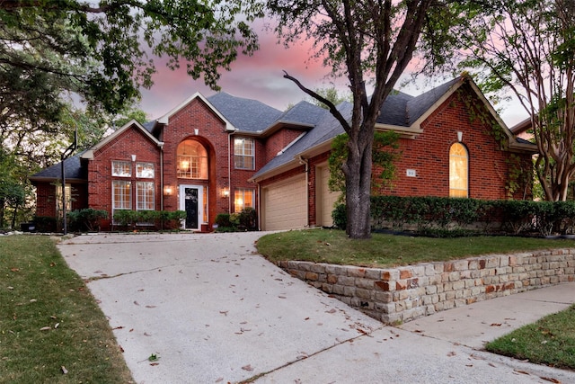 front of property featuring a lawn and a garage