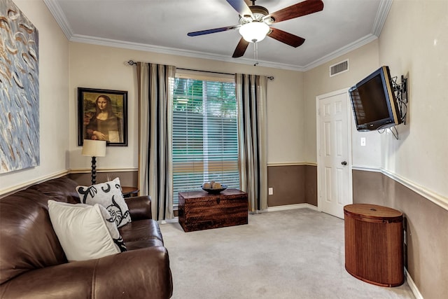 carpeted living room with ceiling fan and crown molding