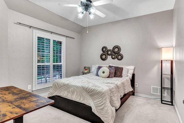 carpeted bedroom with ceiling fan and vaulted ceiling