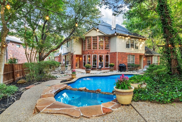 view of swimming pool featuring a patio area and a grill