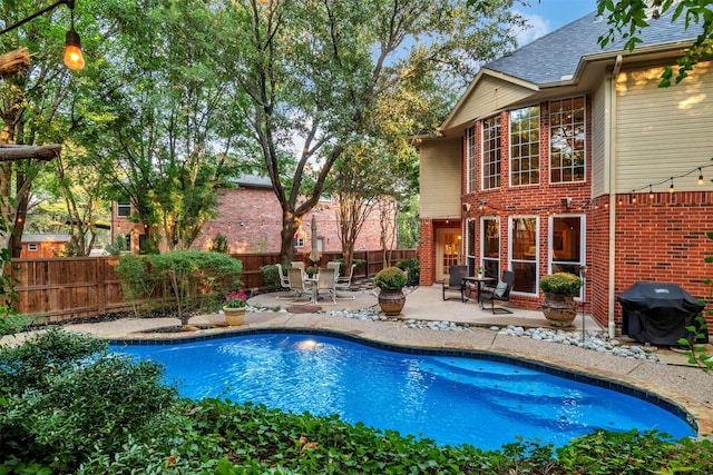 view of swimming pool with grilling area and a patio