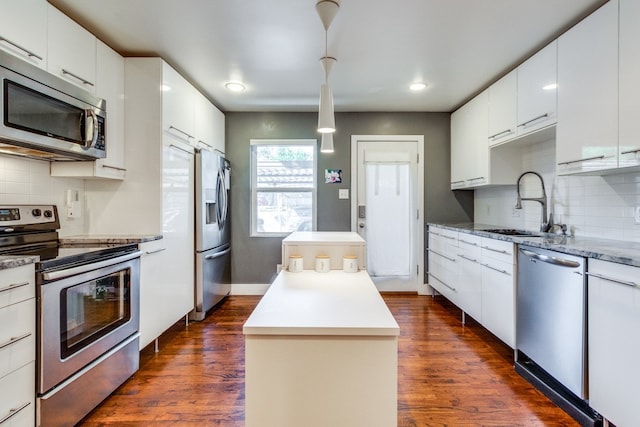 kitchen featuring dark hardwood / wood-style floors, sink, backsplash, appliances with stainless steel finishes, and white cabinetry