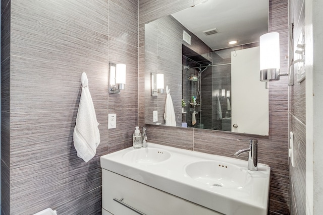 bathroom with vanity, tile walls, and a tile shower