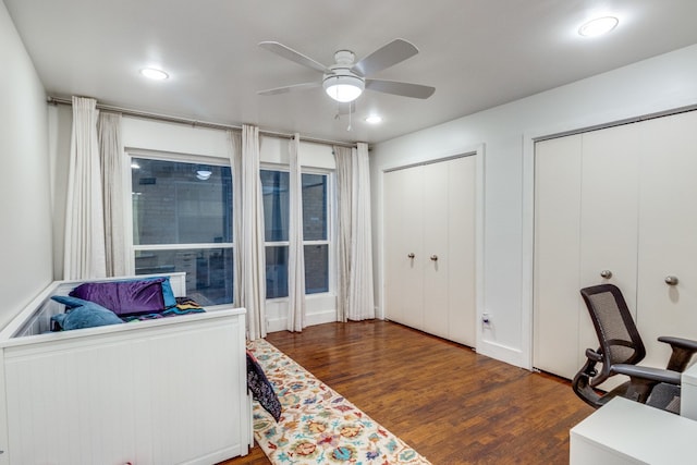 home office with dark hardwood / wood-style flooring and ceiling fan